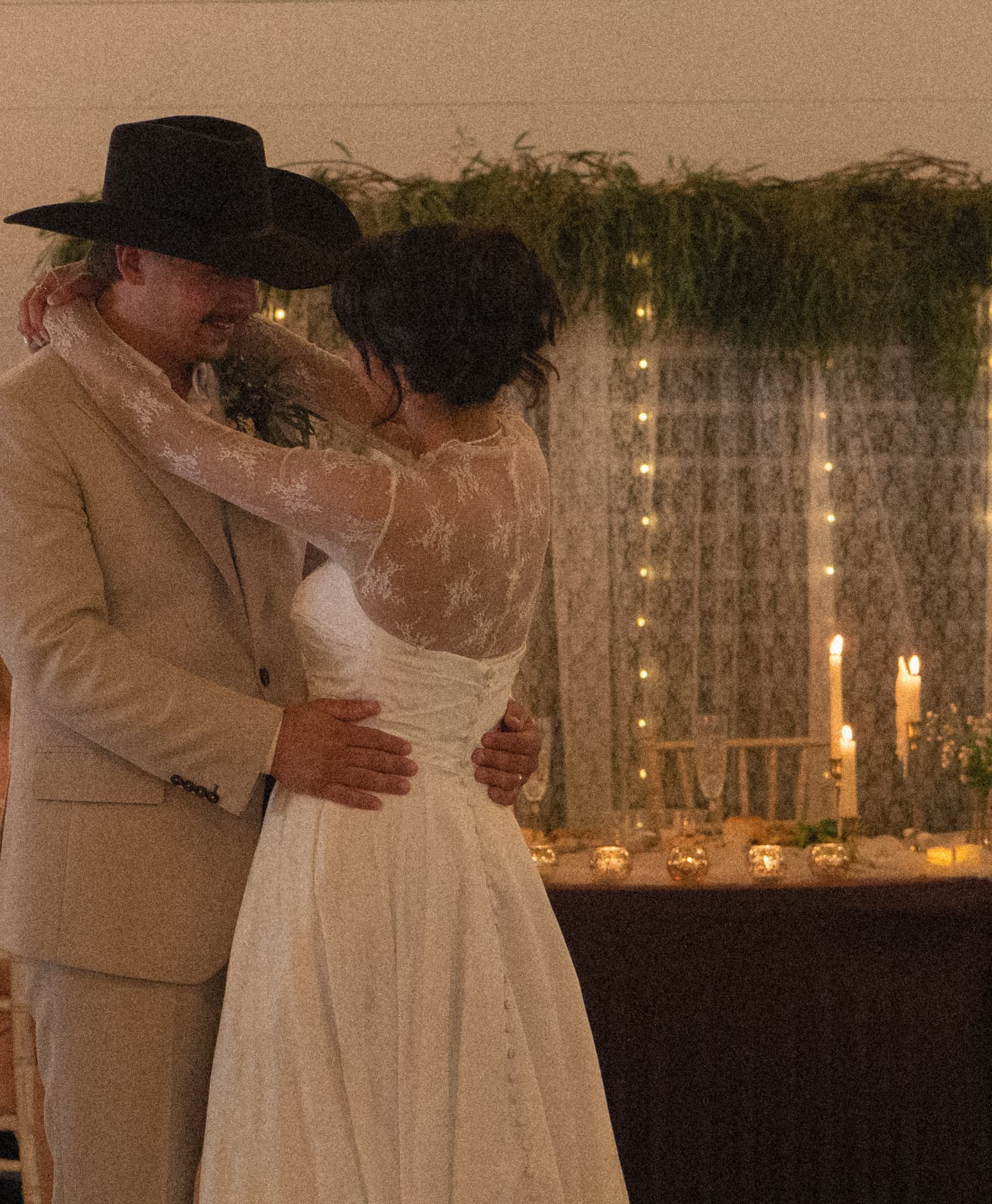 A first dance under string lights and candlelight